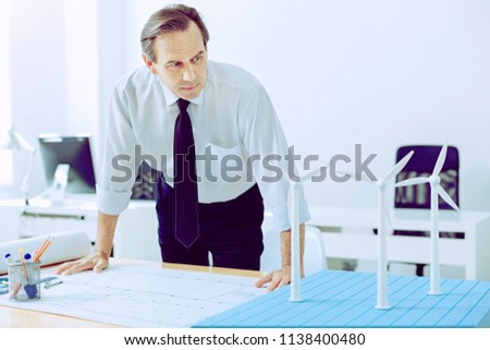 Checking everything. Qualified attentive engineer checking his project before showing it to his clients