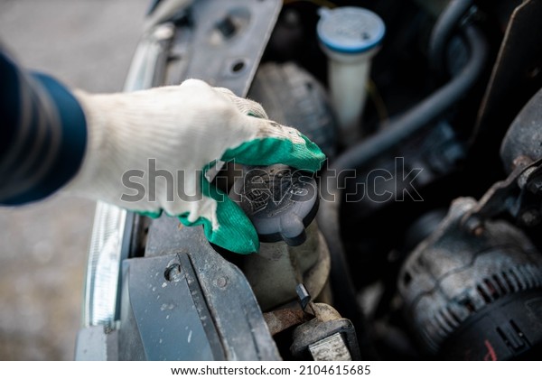 checking the level of antifreeze in the\
coolant in the car, high pressure radiator\
caps.