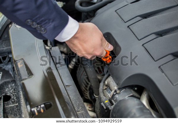 Checking the level of oil in the car\'s engine,\
to protect against possible car\
damage