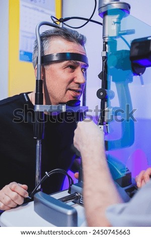 Checking a man's vision with a modern microscope at an appointment with an ophthalmologist. Vision treatment.