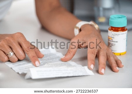 Checking medication information on a pill leaflet to confirm correct use. Emphasizes careful review, safety focus, and organized health routine.