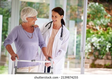 Checking up on the daily progress. Shot of a senior woman using an orthopedic walker, chatting happily with her doctor.