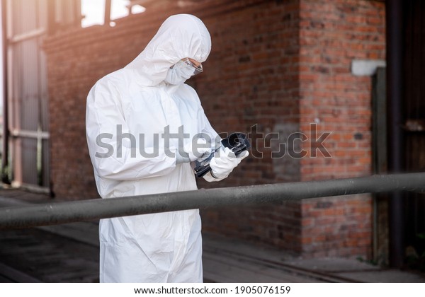 Checking passengers and driver for\
virus, man in biological suit writes data on tablet, car number and\
travel path. concept Life after pandemic COVID-19\
coronavirus.