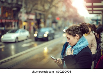 Checking the smartphone while waiting for the bus to come