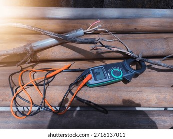 Checking the submersible pump power cable using a multitester.