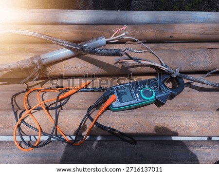 Checking the submersible pump power cable using a multitester.
