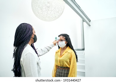 Checking the temperature at the office reception desk before going to work. - Powered by Shutterstock