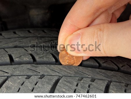 Checking tire tread depth and wear with a penny on Lincoln's head