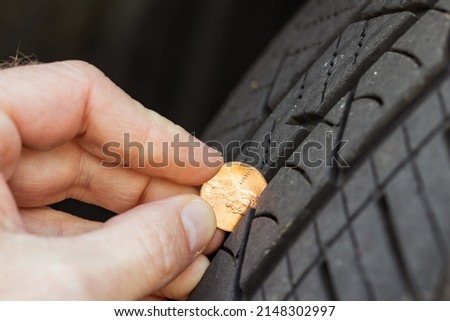 Checking tread depth on a tire by using a penny