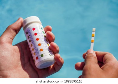 Checking The Water Quality Of A Pool With The Help Of A Test Strip With PH Value, Chlorine And Algaecide