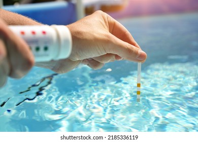 Checking The Water Quality Of A Pool With The Help Of A Test Strip With PH Value, Chlorine And Algaecide