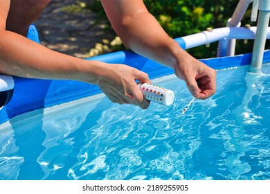 Checking The Water Quality Of A Pool With The Help Of A Test Strip With PH Value, Chlorine And Algaecide