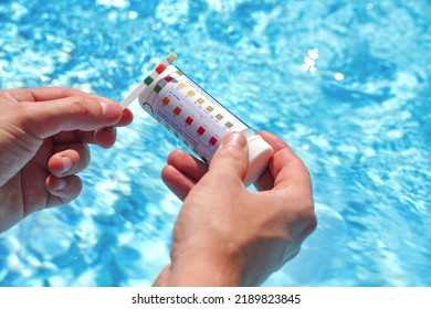 Checking The Water Quality Of A Pool With The Help Of A Test Strip With PH Value, Chlorine And Algaecide