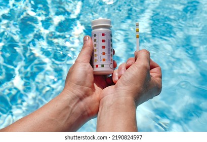 Checking The Water Quality Of A Pool With The Help Of A Test Strip With PH Value, Chlorine And Algaecide