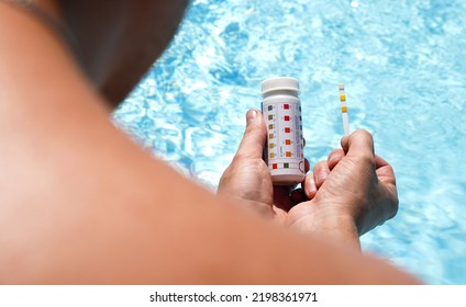 Checking The Water Quality Of A Pool With The Help Of A Test Strip With PH Value, Chlorine And Algaecide