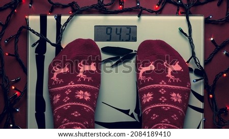 Checking weight using bathroom scale after holiday season. Woman was getting fat during the winter. Feet on a scale