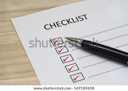Checklist concept - checklist box with red checkmark, paper and a pen with checklist word on wooden table