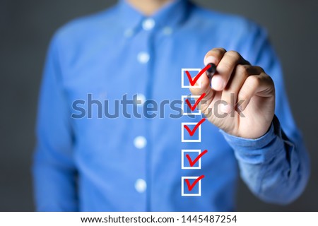 Checklist concept, Businessman checking mark on the check boxes with marker red