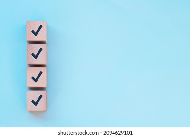 Checklist concept, Check marks on wooden cube blocks, blue background with free copy space - Shutterstock ID 2094629101