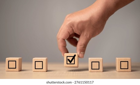 Checklist selection concept with hand choosing approved task block symbolizing efficiency, verification and workflow management. Business quality control, productivity improvement.