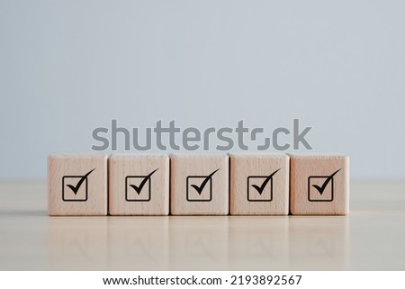 Checklist Survey and assessment. Quality Control. Goals achievement and business success. Check mark icon on wooden blocks.