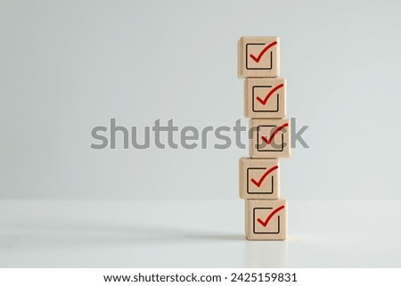 Checklist, Task list, Survey and assessment. Quality Control. Goal achievement and business success. Elections and Voting, Vote, to do list. Red correct check mark icon on stack of wooden blocks.
