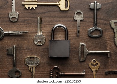 check-lock and different keys on wooden background concept