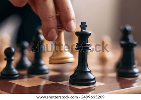 Checkmate. Hand of an unrecognizable man playing chess checkmating his opponent