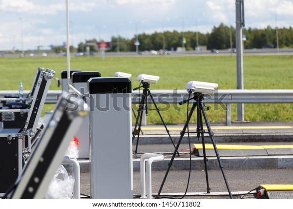 checkpoint police on the road. cameras on tripods and\
equipment in cases for inspection of entering cars on the road.\
Pre-entry inspection\
.