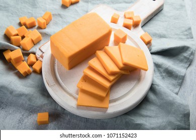 Cheddar Cheese On A Wooden Cutting Board.