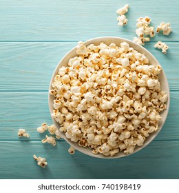 Cheddar Cheese Salted Popcorn In A White Bowl On Light Blue Table Overhead Shot