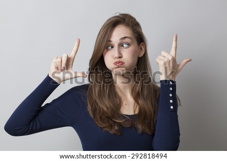 cheeky young girl making the LOL sign with humor for boring trends in hand gesture