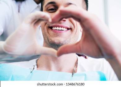 Cheer Of Heart. A Patient With White And Healthy Smile In The Center Of A Heart Made From Two Hands Of A Doctor And A Patient Which Is Telling About Pleasant Emotions Of The Appointment.