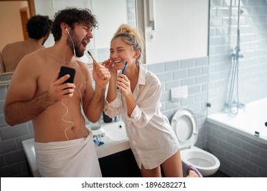 Cheerfu couple brushing teeth together in the morning