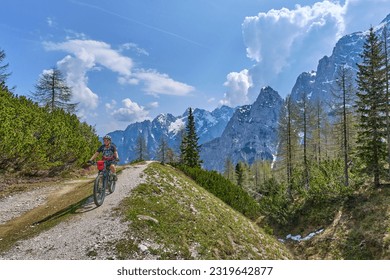 cheerful active senior woman on a E mountain bike tour at Vršič Pass in the Triglav National Park, Julian Alps above Kranska Gora in Slovenia - Powered by Shutterstock