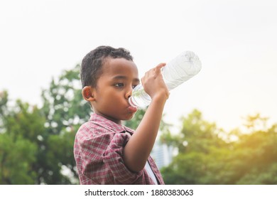 Cheerful African American Boy Drinking Water After Playing At Park