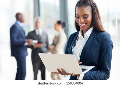 cheerful african american businesswoman using laptop in office