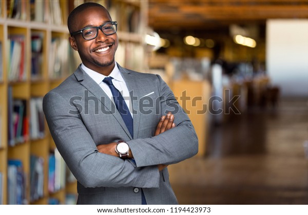 Cheerful African American\
educator university professor, founder, administrator, in\
library