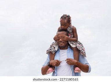 Cheerful African American father and daughter, Father carrying daughter on shoulders, Little girl on the shoulders of her dad - Powered by Shutterstock