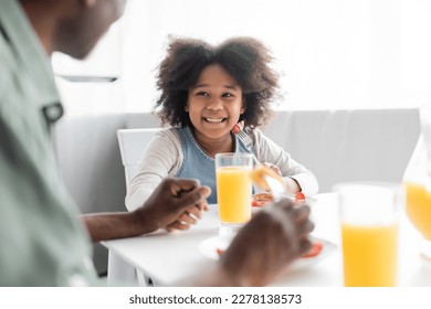 cheerful african american girl looking at grandfather during breakfast at home - Powered by Shutterstock