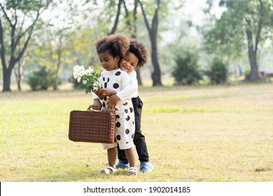 Cheerful African American Little Boy And Girl Playing And Hugging Together In The Park. Children With Curly Hair Having Fun Together Outdoor. Black Kid People Enjoying Outside