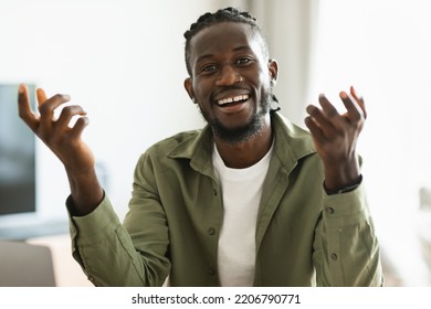 Cheerful African American Man Talking To Camera And Gesturing, Having Video Call While Sitting At Home. Black Guy Communicating Distantly Online. Remote Communication Concept