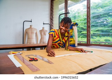 Cheerful African American seamstress at work - concept on fashion industry workers manufacturing - Powered by Shutterstock