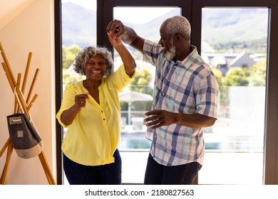 Cheerful african american senior man doing salsa dance with woman against window in nursing home. Friendship, togetherness, enjoyment, unaltered, recreation, support, assisted living and retirement. - Powered by Shutterstock