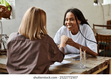 A cheerful African American woman with braided hair smiles at her girlfriend while they share an intimate moment. - Powered by Shutterstock