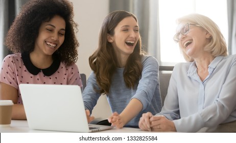 Cheerful African And Caucasian Businesswomen Laughing Having Fun Good Relations Chatting At Workplace, Happy Diverse Different Age Generations Enjoying Talking Joking Together In Office At Work Break