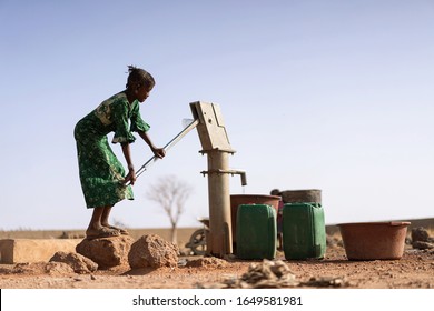 Cheerful African ethnic Girl Bringing Crisp Water in a village