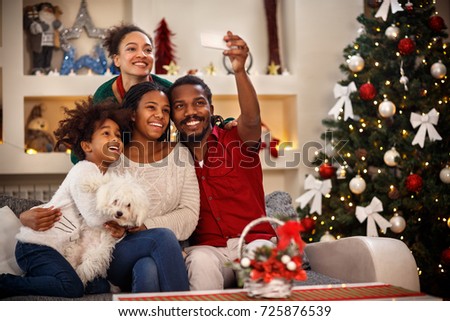 Cheerful African family making selfie together for Christmas