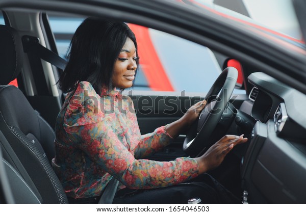 cheerful african\
female driver inside a\
car