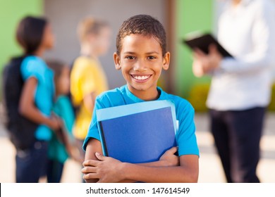 Cheerful African Male Elementary School Student Holding Text Books